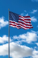 Flag waving against a blue sky with white fluffy clouds