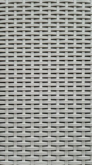 Close-up of woven plastic surface of laundry basket. Close-up of synthetic plastic pattern. Close-up of woven surfaces of plastic household baskets. Texture. Plastic rattan with symmetrical pattern