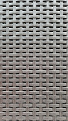 Close-up of woven plastic surface of laundry basket. Close-up of synthetic plastic pattern. Close-up of woven surfaces of plastic household baskets. Texture. Plastic rattan with symmetrical pattern