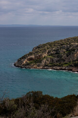 A scenic vanlife stop along the coastline of central Peloponnese, Greece. A camper van is parked by the sea, with a stunning view of the blue waters and distant mountains.