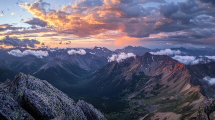 Obraz premium Dramatic sunset over rugged mountain peaks with vibrant orange and purple sky