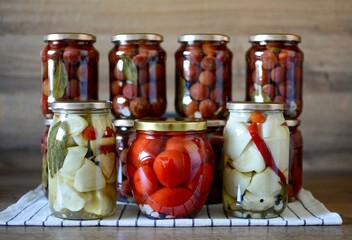 Pickling vegetables in glass jars. Patisson, tomato, paprika, hot pepper, garlic, black pepper, bay leaf, vinegar.