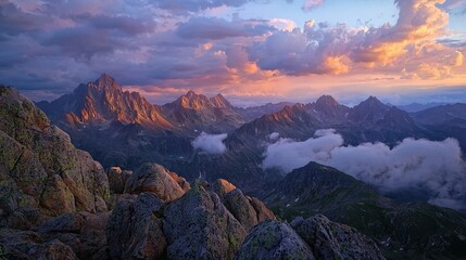 Obraz premium Majestic mountain range at sunset with golden light and dramatic clouds