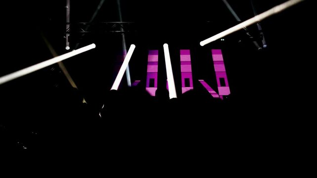 Dark outlines of dancers grooving under disco lights