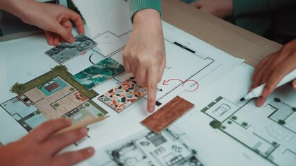 A team collaborates on an interior design project, selecting textures and materials from vibrant samples while drafting their creative ideas on a workspace. SACTR