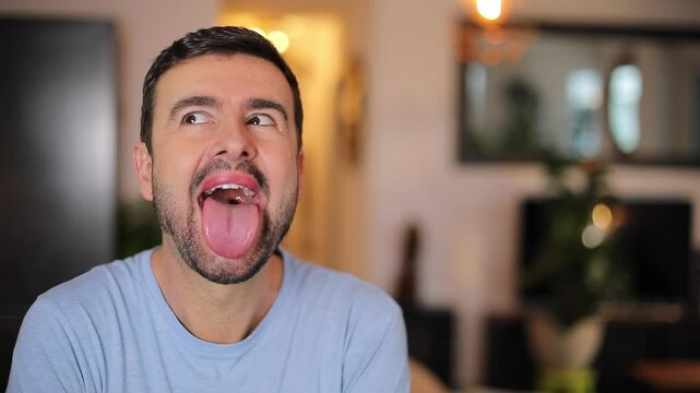 A man opens his mouth widely and sticks his tongue out