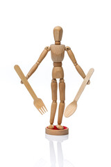 Wooden toy mannequin  holding disposable wooden fork and spoon on a white background.
