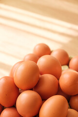 Brown egg pile on wooden surface with soft morning light creating a warm and inviting atmosphere