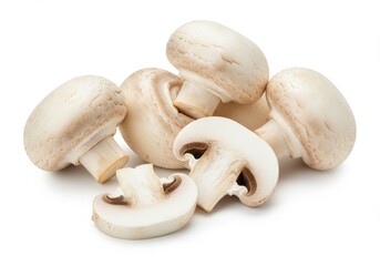 A close up shot of several white button mushrooms with one sliced in half on a white background