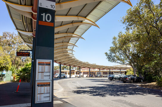 A modern bus terminal at Bendigo Railway Station in Australia, featuring curved canopy roofs providing shade over the passenger waiting areas and pick-up zones