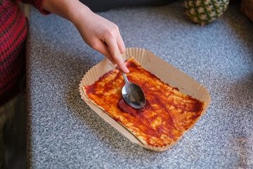 Girl Preparing Mini Pizza with Tomato Sauce for Air Fryer.