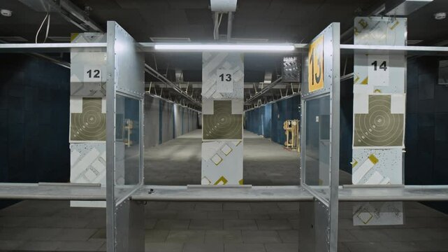 Full zoom-in no people of metal stall at shooting gallery or gun club, equipped with mirror, target on retrieval system, in soundproof training facility before practice