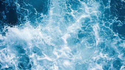 Aerial view of churning blue water with white foam and wave patterns.