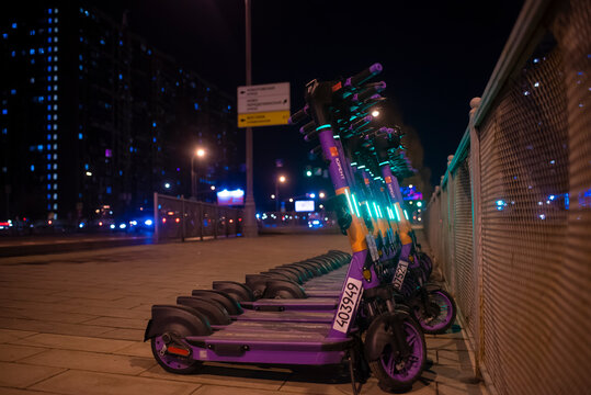 Moscow, Russia. March 21, 2025. Rental point purple electric scooters at night