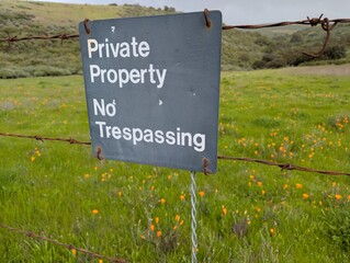 No trespassing sign in a field of California poppies. 