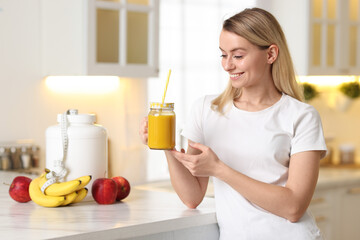 Weight loss. Woman with tasty shake near white marble table in kitchen