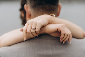 Beautiful bride holds her hands behind the grooms head. Wedding photo of beautiful newlyweds newlyweds close-up outdoors.