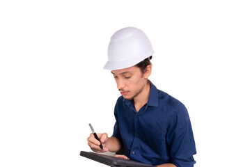 Young architect wearing white helmet, sitting, working with tablet. Isolated on white background.