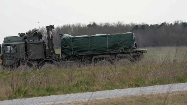 British army MAN EPLS 8x8 logistic truck carrying supplies across countryside