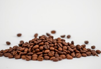 Naklejka premium Pile of Roasted Coffee Beans on White Background 
