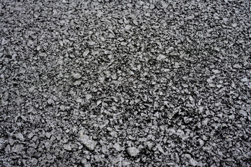 Close-up of rough asphalt pavement texture
Detailed view of coarse asphalt surface, showing compacted gravel and bitumen mix typical of roads, driveways, or parking areas.

