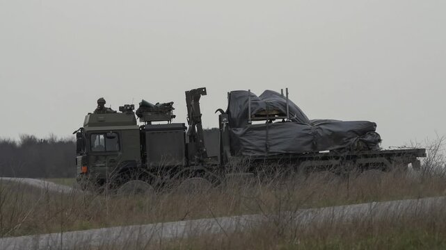 British army MAN EPLS 8x8 logistic truck carrying supplies across countryside