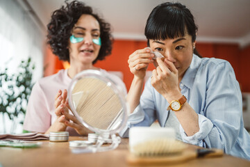 female friends share skincare moment use eye patches relax together