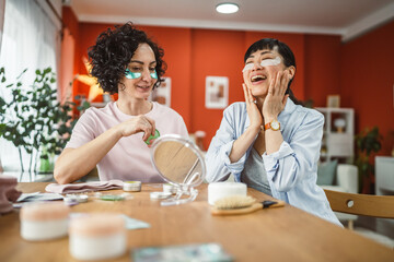 female friends share skincare moment use eye patches relax together