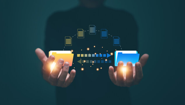 Information exchange and file transfer concept. Businessman holding folder icon for transfer file of data between folders. FTP (File Transfer Protocol). Files recovery computer backup.