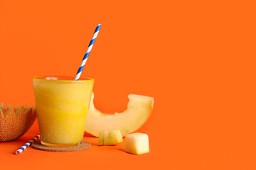 Glass of tasty melon smoothie on orange background