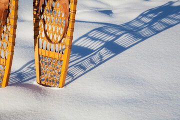 shadow of vintage Bear Paw snowshoes in snow