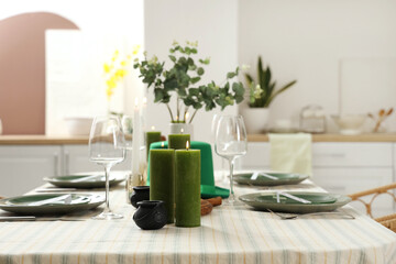 Festive table serving with leprechaun's hat and burning candles in dining room. St. Patrick's Day...