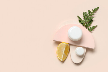 Composition with piece of lemon, fern twig, jars of cosmetic product and plaster stands on light...