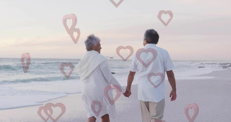 Walking on beach, elderly couple holding hands with heart animation overlay - Powered by Adobe
