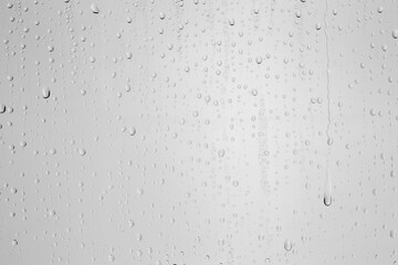 Water drops on light grey glass surface, top view