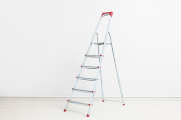 Maintenance ladder near white wall