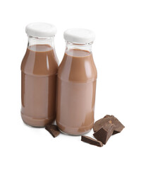 Tasty chocolate milk in glass bottles and pieces of chocolate isolated on white