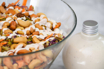 Broccoli Cashew Salad in a glass bowl include broccoli, cashews, and other vegetables closeup side view of gourmet nut salad
