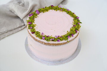 Pistachio Rose Cake with floral decor, pistachio and rose petal garnish napkin side view of elegant cake perfect for celebrations