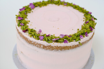 Pistachio Rose Cake with floral decor, pistachio and rose petal garnish closeup side view of elegant cake perfect for celebrations