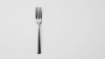 A single, sleek fork rests on a minimalist white background.