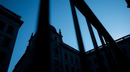 Silhouetted building at dawn, framed by metal