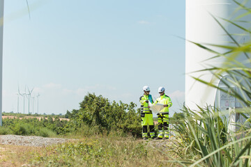 Obraz premium Team of electrical engineer is perform the inspection and maintenance of electric generating windmill turbine.