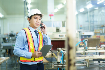Asian engineer manager checks the machine and system in facility.