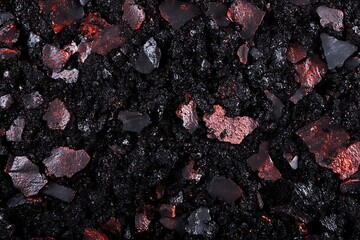 Dark asphalt texture with red inclusions provides a unique surface detail for backgrounds