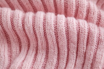 Close-up of soft pink knitted fabric with ribbed texture and cozy feel for backgrounds and designs