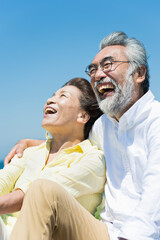 Fototapeta premium 青空の下で笑い合うシニア夫婦