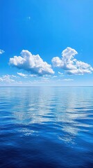 Obraz premium A Clear Day Presents Ocean Water And Fluffy White Clouds Above
