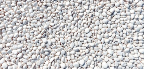 A scattering of smooth, white pebbles forms a textured background, background, design, close-up