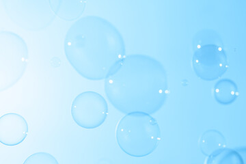 Beautiful Blue Soap Bubbles Floating in The Air. Celebration Festive Backdrop. Freshness Soap Suds Bubbles Water. Blue and White Gradient Textured .Abstract Background.
